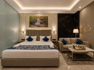 a bedroom with a king sized bed and a couch at Hotel The Grand Villa by Signature Stayz Near International Airport in New Delhi +20 photos