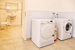 eine Waschküche mit einer Waschmaschine und einem Waschbecken in der Unterkunft Ferienhaus-Marina in Goslar