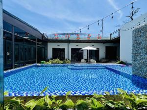 a large blue swimming pool next to a building at PALM Minh Chau Hotel-Only for Vietnamese in Quang Ninh