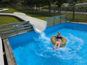 a woman riding a raft in a pool on a water slide at Trellebystrands Camping in Lysekil +14 photos