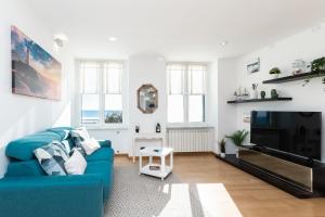 a living room with a blue couch and a television at -Fronte Mare- Centro Storico in Varazze