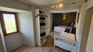 a small room with a crib and a room with a bedroom at Le Zell in Zellenberg
