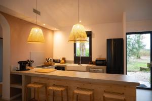 a kitchen with two lights and a counter with stools at La Casa M-maison idéale pour groupes familles amis 12 personnes au calme avec piscine in Sainte-Hélène