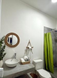 a bathroom with a green shower curtain and a sink at Bamboo in El Paredón Buena Vista