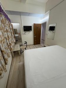 a hotel room with a bed and a television at Ghate rooms in Nagpur