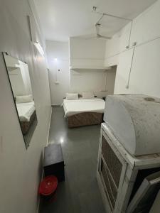a small room with two beds and a mirror at Ghate rooms in Nagpur