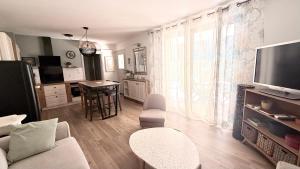 a living room with a couch and a tv at Appartement golf saumane Celomidie in Saumane-de-Vaucluse