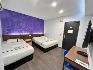 a hotel room with two beds and a tv at Smile Hotel Cheras Pudu KL in Kuala Lumpur