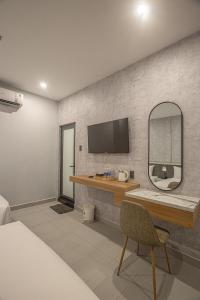 a bedroom with a mirror and a desk and a bed at Dan Thanh Hotel in Can Tho