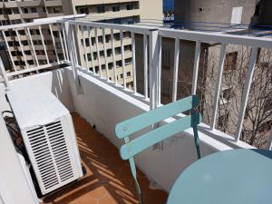 a blue chair sitting on a balcony with an air conditioner at Appartement Casella in Bastia +5 photos