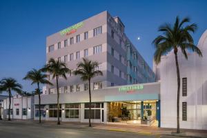 a building with palm trees in front of a street at Courtyard Miami Beach South Beach in Miami Beach