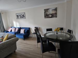 a living room with a table and a blue couch at The Flexible Lodge-Ashford in Kingsnorth