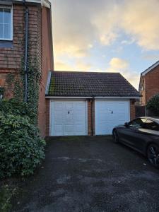 a car parked in front of a garage at The Flexible Lodge-Ashford in Kingsnorth