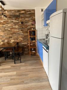a kitchen with a white refrigerator and a table at 2 Chambres Centre Station 1600 in Puy-Saint-Vincent