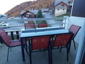 a table and chairs on a balcony with a view at 2 Chambres Centre Station 1600 in Puy-Saint-Vincent +2 photos