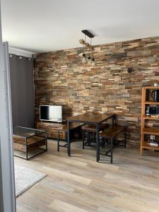 a dining room with a table and a brick wall at 2 Chambres Centre Station 1600 in Puy-Saint-Vincent