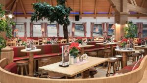 a restaurant with tables and stools in a room at Alpine Hotel in Bispingen +28 photos