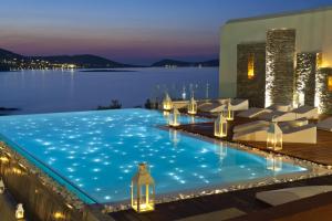 a swimming pool with a view of the water at night at Hotel Senia - Onar Hotels Collection in Naousa