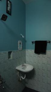 a bathroom with a white sink and a blue wall at Grey Pearl Homestay in Pondicherry