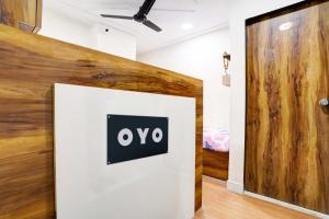 a wall with an ovo sign on it in a room at Hotel O Apollo in Bodakdev