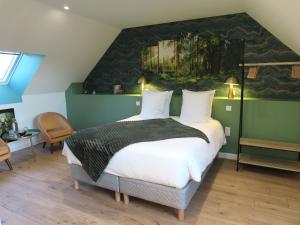 a bedroom with a large bed with a painting on the wall at Le Foyer Celtique in Ploërmel +13 photos