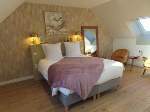 a bedroom with a large bed and a mirror at Le Foyer Celtique in Ploërmel