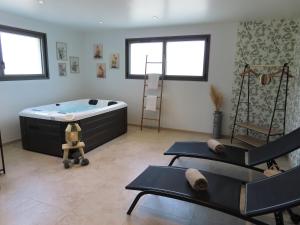 a room with a bath tub and two chairs at Le Foyer Celtique in Ploërmel