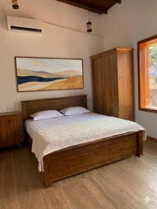 a bedroom with a bed and a painting on the wall at Villa 55 Galle in Galle