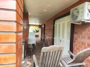 a porch with two rocking chairs and a brick wall at Posada Das Araucárias in Caxias do Sul