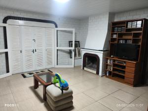 a living room with a toy dinosaur sitting on a chair at Posada Das Araucárias in Caxias do Sul