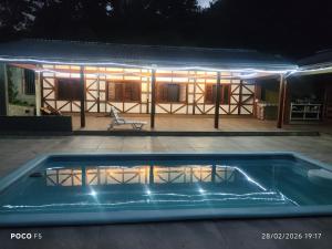 a house with a swimming pool at night at Posada Das Araucárias in Caxias do Sul