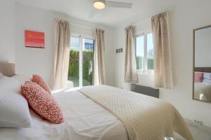 a bedroom with a white bed with pillows and windows at Cordonyer in Port de Pollensa +37 photos