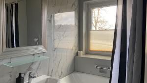 a white bathroom with a sink and a window at Zollhaus 26 in Hohegeiß