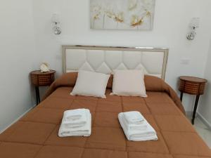 a bed with two white towels on top of it at LETIZIA'S HOME Caserta in Caserta