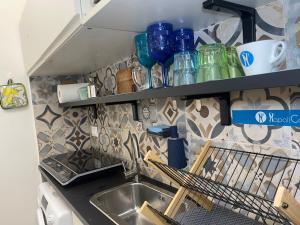a kitchen with a sink and a shelf with glasses at Dolce Hogar Residence in Chiavari