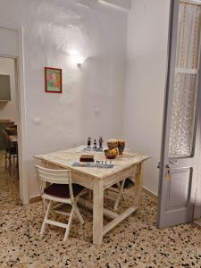 a wooden table with two chairs in a room at Antica dimora LUNA in Casarano