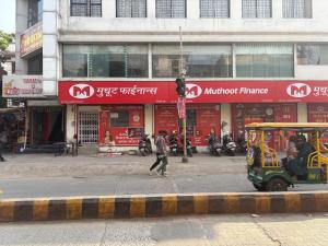 a man crossing a street in front of a building at Ghate rooms in Nagpur