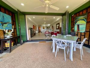 a dining room with a white table and chairs at Kata Seaview Escape - 1BR Luxury Apartment 90sqm in Phuket