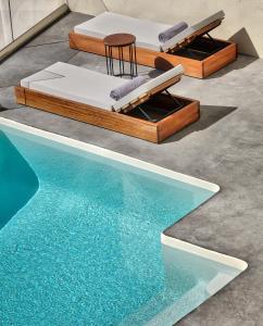 2 camas y una piscina al lado de una casa en Villa Ioli Anastasia, en Firostefani