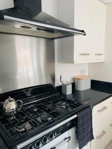 a kitchen with a stove with a tea pot on it at Number 15 in Whitstable