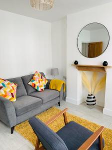 a living room with a gray couch and a mirror at Number 15 in Whitstable +3 photos