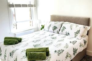 a bedroom with a bed with green pillows at Number 15 in Whitstable