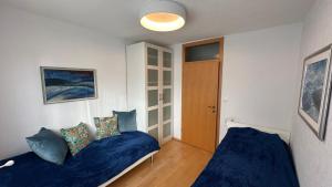 a bedroom with two beds with blue pillows at Ani's Pearl in Bled