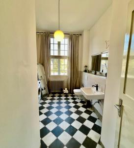 a bathroom with a checkered floor and a sink at Baroque Palais Timber House Celle in Celle +29 photos