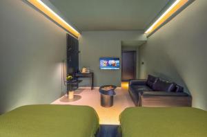 a living room with two green beds and a couch at Yangshuo B&G Hotel-Exclusive location,Roof Top Viewing Terrace,Seasonal swimming pool,Free Self-Service Laundry & Drying, Entrance Ticket Serivce, Local Trip plan,E-Scooter& English Customer Service in Yangshuo