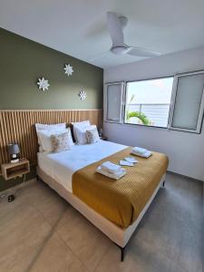 a bedroom with a large bed with towels on it at Villa Gommier - 3 chambres, 3 sdb, piscine in Le Diamant +33 photos