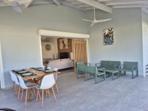 a living room with a table and chairs and a couch at Villa Gommier - 3 chambres, 3 sdb, piscine in Le Diamant