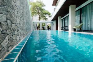 a swimming pool with blue water in a building at Carista Hotel in Vientiane