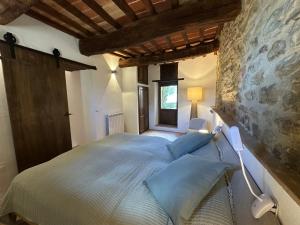 a bedroom with a large bed in a stone wall at Villa Amici Apartment in Fontignano