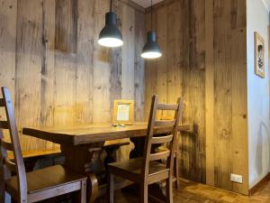 a wooden table and chairs in a room with wooden walls at Bardonecchia Holidays in Bardonecchia